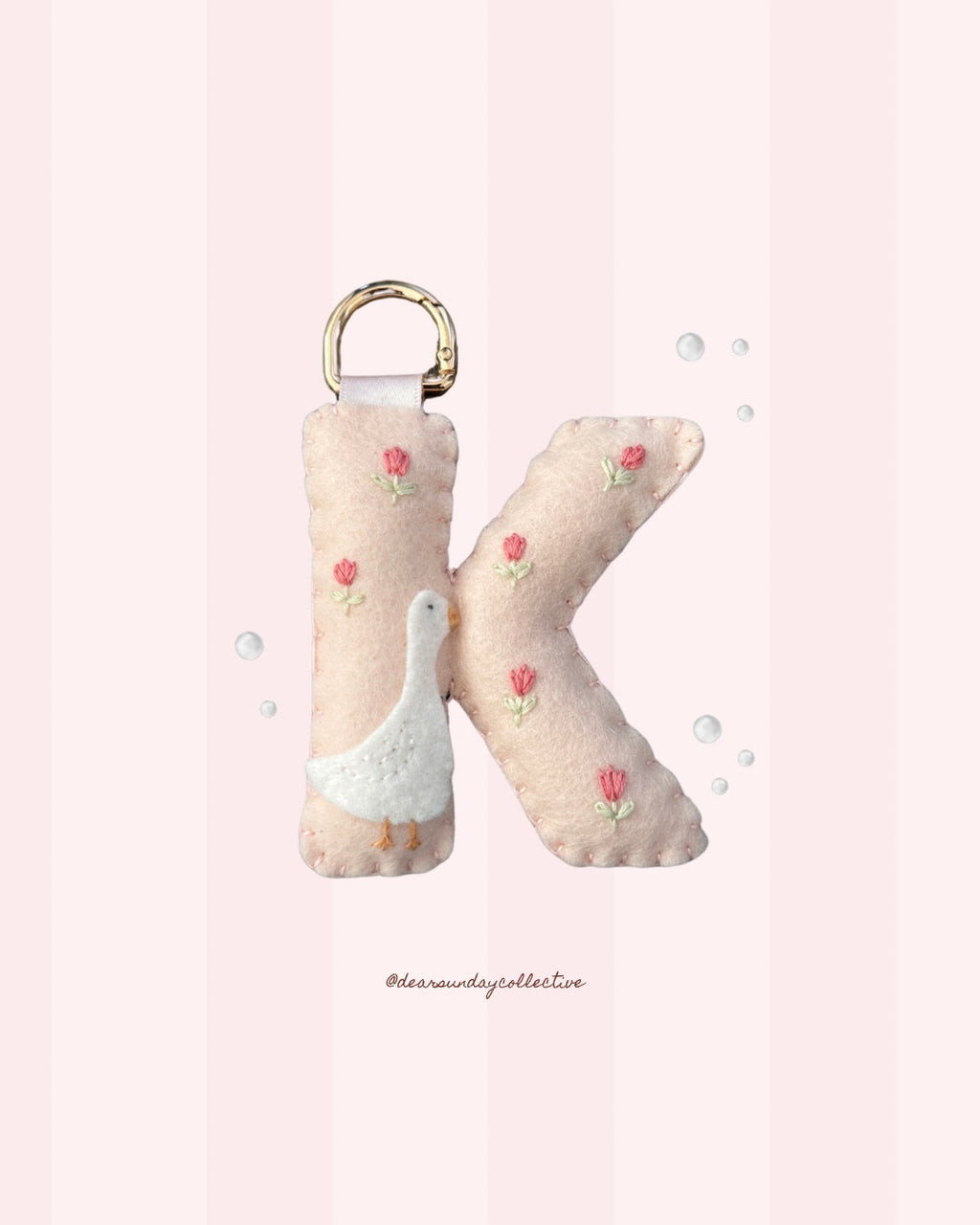 pastel merino wool felt letter keychain with goose and embroidered tulip design and gold metal carabiner, handmade in new zealand.